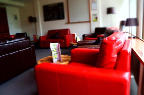 - un salon avec des fauteuils rouges et des canapés dans l'établissement YHA Conwy, à Conwy