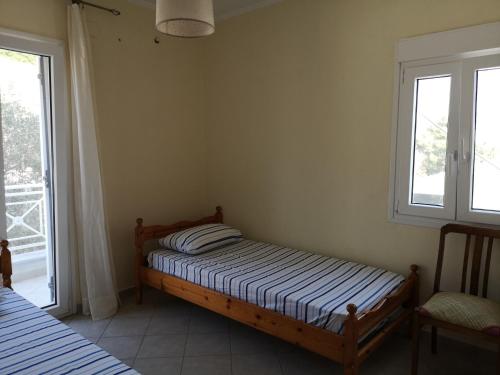 sypialnia z łóżkiem i oknem w obiekcie Nostos - Psili Ammos Apartments w mieście Psili Ammos