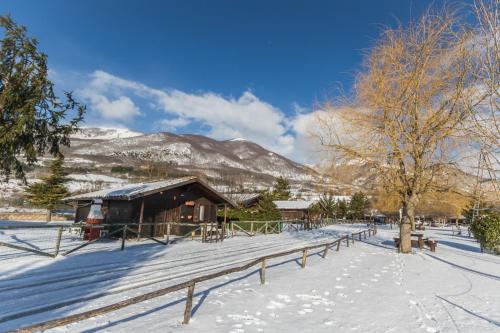 a cabin in the snow in front of a mountain at Parco Del Sangro in Castel di Sangro