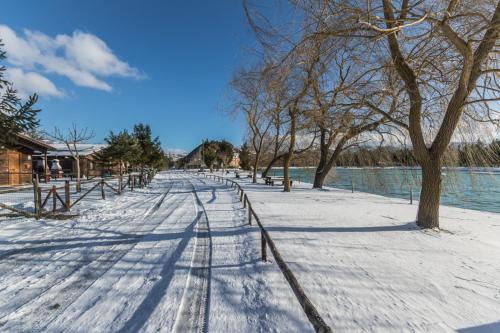 a snow covered street with trees and a fence at Parco Del Sangro in Castel di Sangro