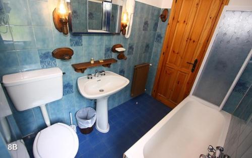 a bathroom with a sink and a toilet and a tub at Champoluc Apartment in Champoluc