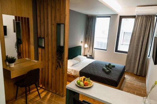 um quarto com uma cama e uma tigela de fruta no balcão em Glam Boutique Apartments - Thessaloniki Heart em Tessalónica