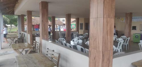 a restaurant with white chairs and tables and people at Pousada e Restaurante Império do Marisco in Maragogi