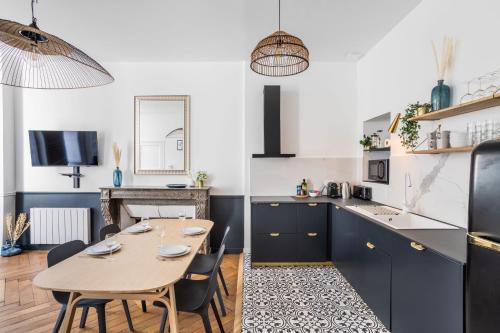 une cuisine et une salle à manger avec une table et des chaises dans l'établissement BEAUTÉ - Appartement chaleureux et moderne, à Rennes
