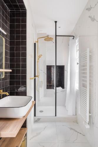 une salle de bain avec une baignoire, une douche et un lavabo dans l'établissement BEAUTÉ - Appartement chaleureux et moderne, à Rennes