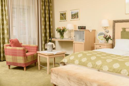 a hotel room with a bed and a chair at Hotel Restaurant zur Post in Melk