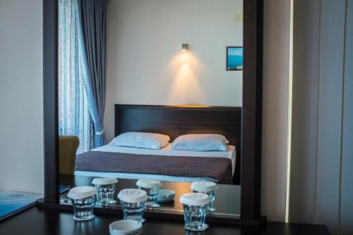 a hotel room with a bed and a mirror at Hotel Neptun Kvariati in Kvariati