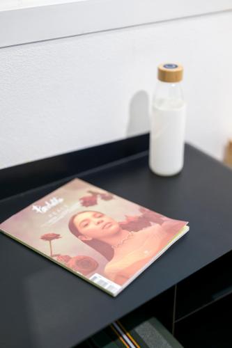 a magazine sitting on a table next to a bottle of glue at Eklo Hotels Le Havre in Le Havre