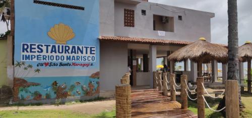um edifício com um sinal para um restaurante em Pousada e Restaurante Império do Marisco em Maragogi
