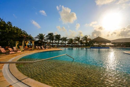 una piscina en un complejo con palmeras en Dom Pedro Laguna Beach Resort & Golf, en Aquiraz
