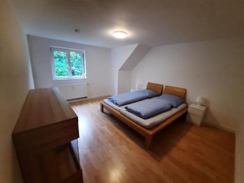 Un dormitorio con una cama con sábanas azules y una ventana. en Ferienwohnungen Bögner, en Günzburg