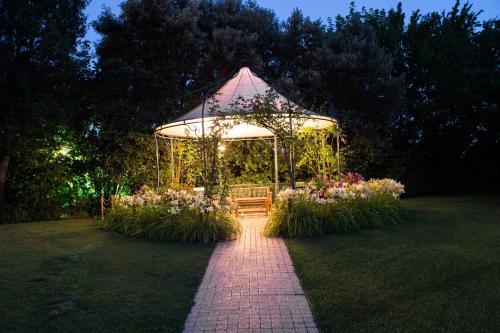 a gazebo with a bench in a garden at night at Osteria Alla Pasina in Dosson