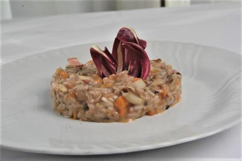 a white plate with a dish of food on a table at Osteria Alla Pasina in Dosson