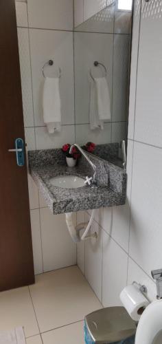 a bathroom with a sink and a toilet at Pousada e Restaurante Império do Marisco in Maragogi