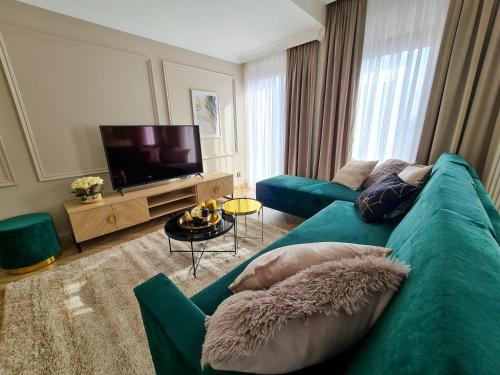 a living room with a blue couch and a television at Apartamenty Hallera 4 in Jarocin