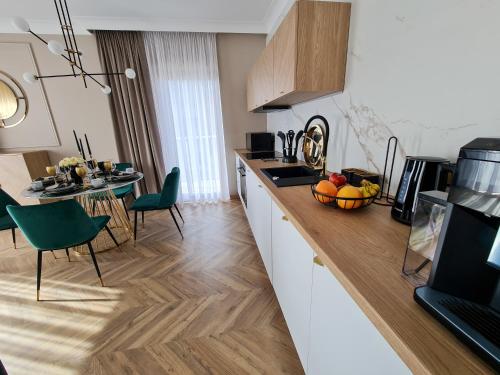 a kitchen with a counter and a table with a bowl of fruit at Apartamenty Hallera 4 in Jarocin