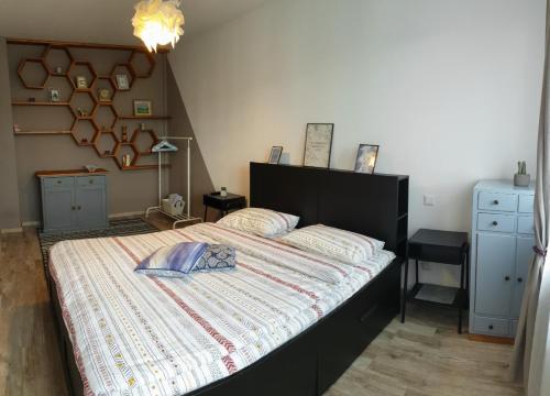 1 dormitorio con 1 cama grande y edredón a rayas en Arsan home, en Cluj-Napoca