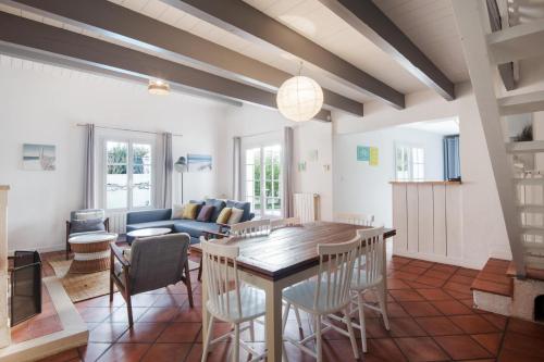 un salon avec une table, des chaises et un canapé dans l'établissement TETHYS VILLA AVEC PISCINE ET PROCHE DE LA MER, à Sainte-Marie de Ré