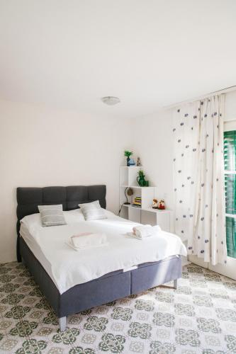 a white bedroom with a large bed in a room at Barba Zoran in Bol