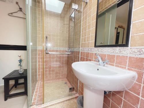 a bathroom with a sink and a glass shower at The Snooze Hotel Marine Parade in Singapore