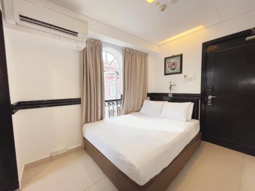 a bedroom with a white bed and a window at The Snooze Hotel Marine Parade in Singapore