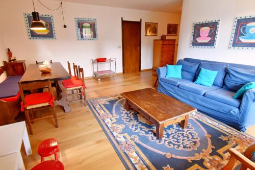 a living room with a blue couch and a table at Appartamento al Passo in Madonna di Campiglio