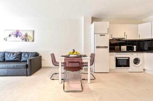 una cucina e un soggiorno con tavolo e divano di Hortensia Suites Apartments ,Los Cristianos a Los Cristianos