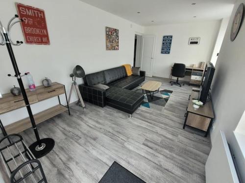 a living room with a couch and a table at charmant appartement confort déco neuf , proche Epinal et Lac de Bouzey in Uxegney