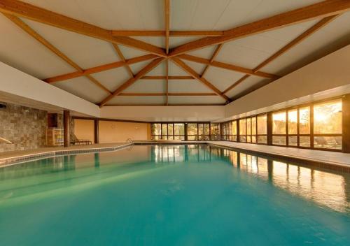 a large swimming pool in a building at Evora Hotel in Évora