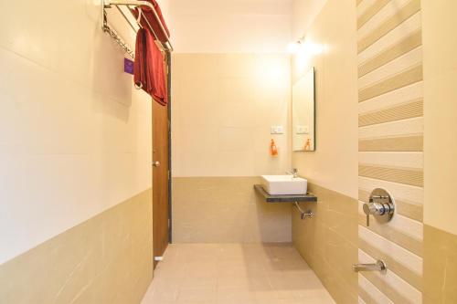 een badkamer met een wastafel en een spiegel bij H2O Greens Villa in Lonavala