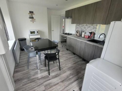 a kitchen with a table and chairs in a kitchen at charmant appartement confort déco neuf , proche Epinal et Lac de Bouzey in Uxegney