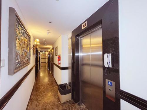 a hallway with a metal elevator in a building at The Snooze Hotel Marine Parade in Singapore