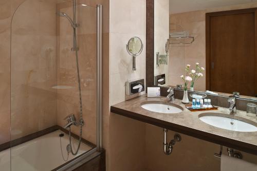 a bathroom with two sinks and a shower at Hipotels Sherry Park in Jerez de la Frontera