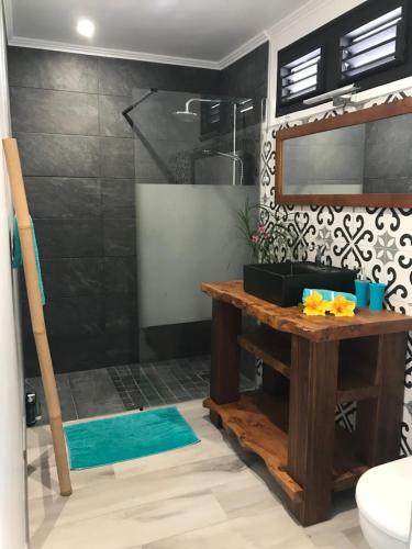 a bathroom with a shower with a wooden table at appartement privé ECO-RESPONSABLE, magnifique vue sur la mer des Caraibes et jardin clos, WiFi, à 2mn de la plage in Sainte-Luce