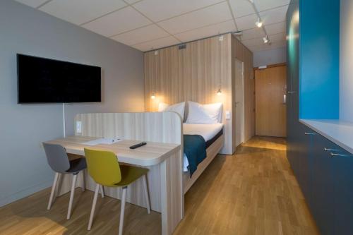 a hotel room with a bed and a table and chairs at Scandic Kista in Stockholm