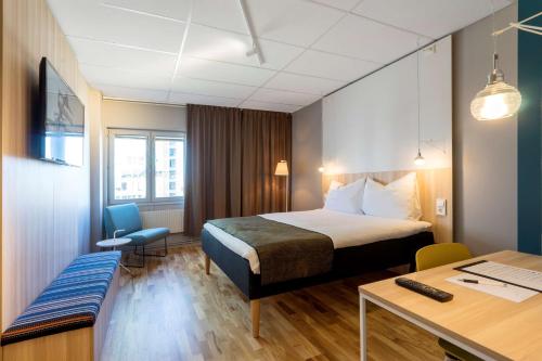 um quarto de hotel com uma cama e uma secretária em Scandic Kista em Estocolmo