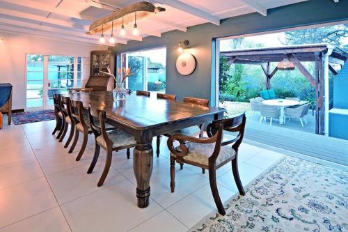 a dining room with a large wooden table and chairs at B&B on Buckingham Guest House in Johannesburg