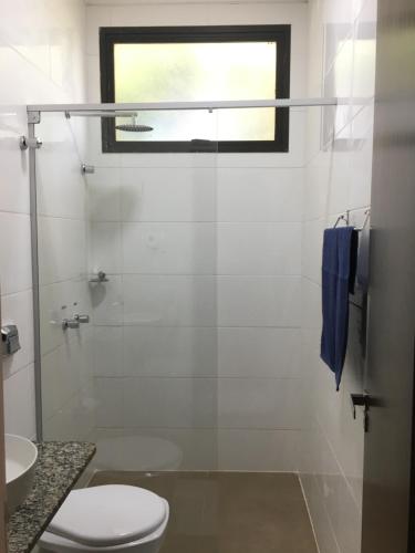 a bathroom with a shower and a toilet and a window at Skala Park Hotel in Sertãozinho