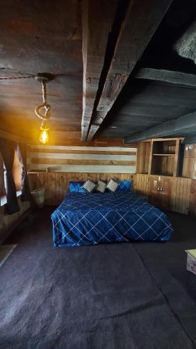 a bedroom with a blue bed in an attic at Time Trael in Manāli