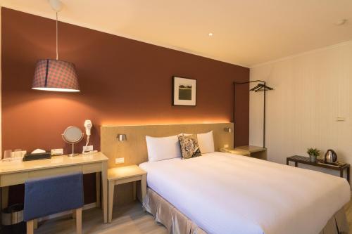 a hotel room with a bed and a desk and a computer at Just Enjoy Business Hotel in Tainan