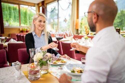 a group of people sitting around a table in a restaurant at Familien- Sportresort BRENNSEEHOF in Feld am See