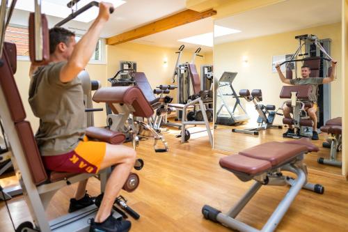 a man in a gym with several exercise equipment at Familien- Sportresort BRENNSEEHOF in Feld am See