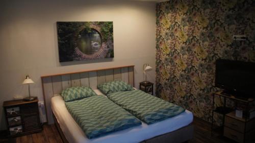 a bedroom with a bed and a flat screen tv at Ferrum Ferrum in Valkenburg