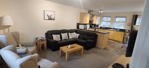 un soggiorno con divano e cucina di The Cobbler Cottage - Loch Lomond and Arrochar Alps ad Arrochar