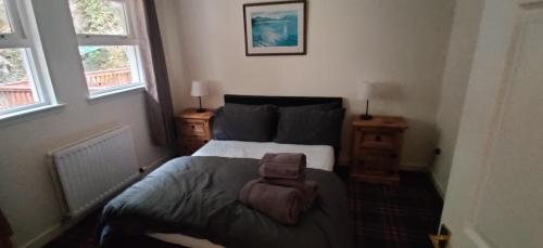 1 dormitorio con 1 cama y 2 ventanas en The Cobbler Cottage - Loch Lomond and Arrochar Alps, en Arrochar