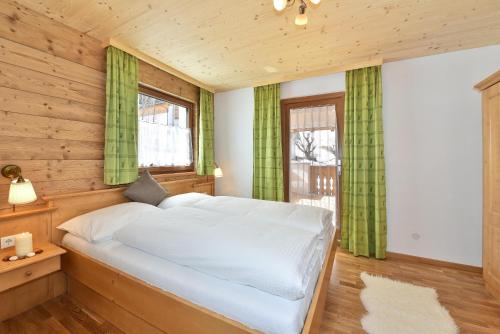 1 dormitorio con 1 cama grande y cortinas verdes en Joselehof App Arnika en Stanghe