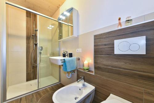 La salle de bains est pourvue d'un lavabo, d'une douche et de toilettes. dans l'établissement Joselehof App Arnika, à Stanghe