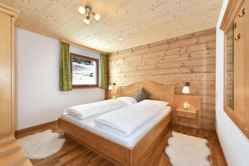 1 dormitorio con 1 cama en una cabaña de madera en Joselehof App Enzian en Stanghe