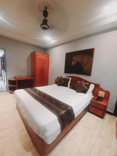 a bedroom with a large white bed in a room at Hotel JMC Group in Rajkot