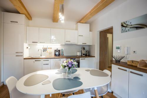 a white kitchen with a white table and chairs at Ski Chalet Klínovec in Loučná pod Klínovcem